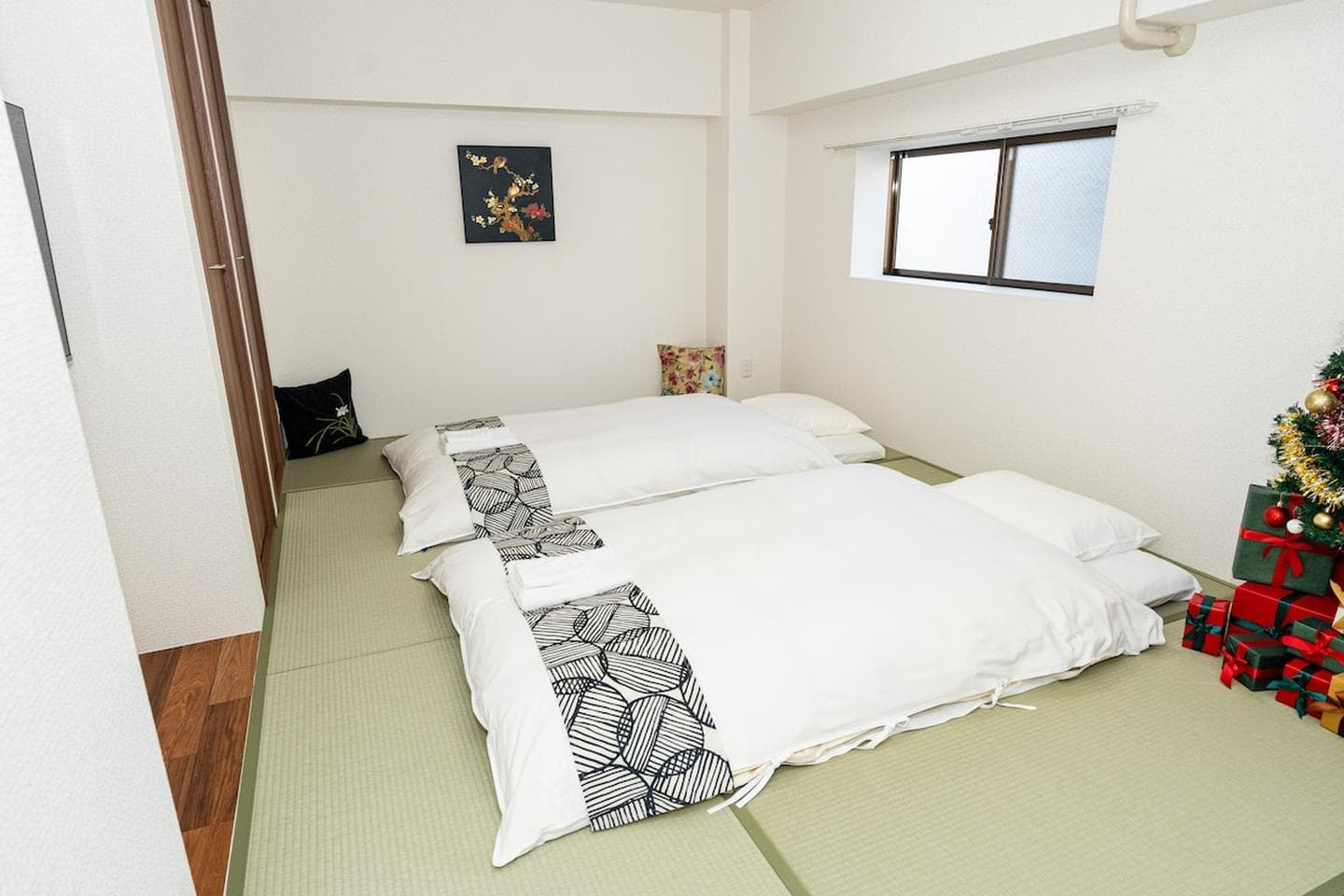 Two Japanese futon beds laid out on tatami mats in a bright bedroom.