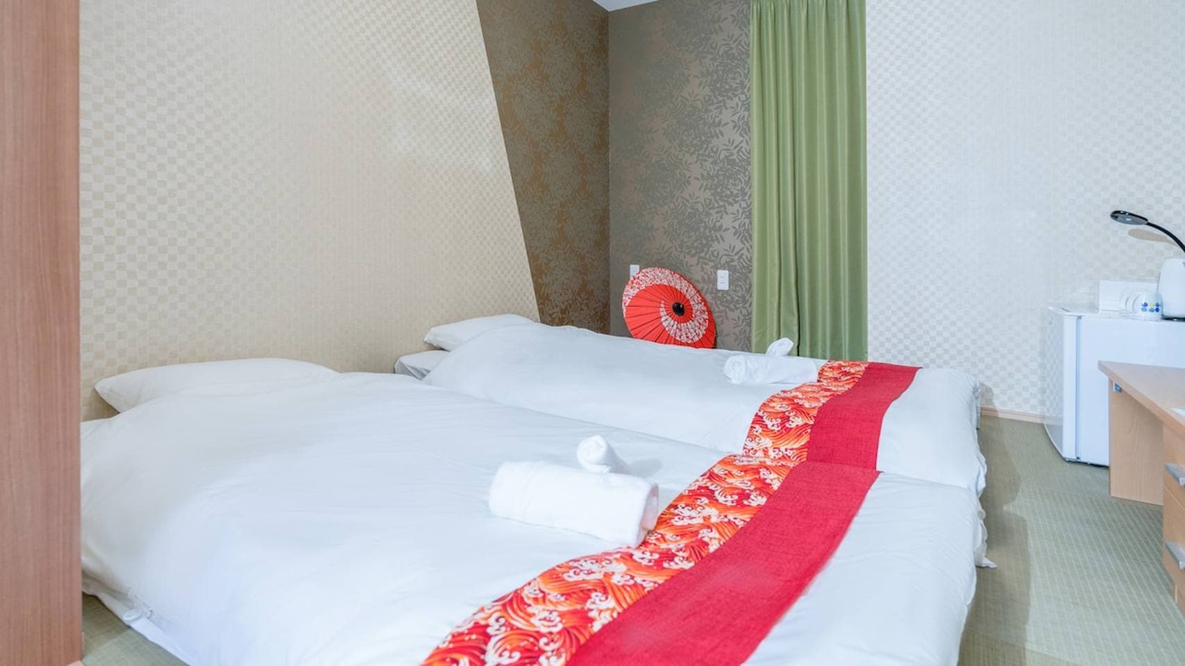 Two twin beds with white linens and red decorative runners in a Japanese-style bedroom.