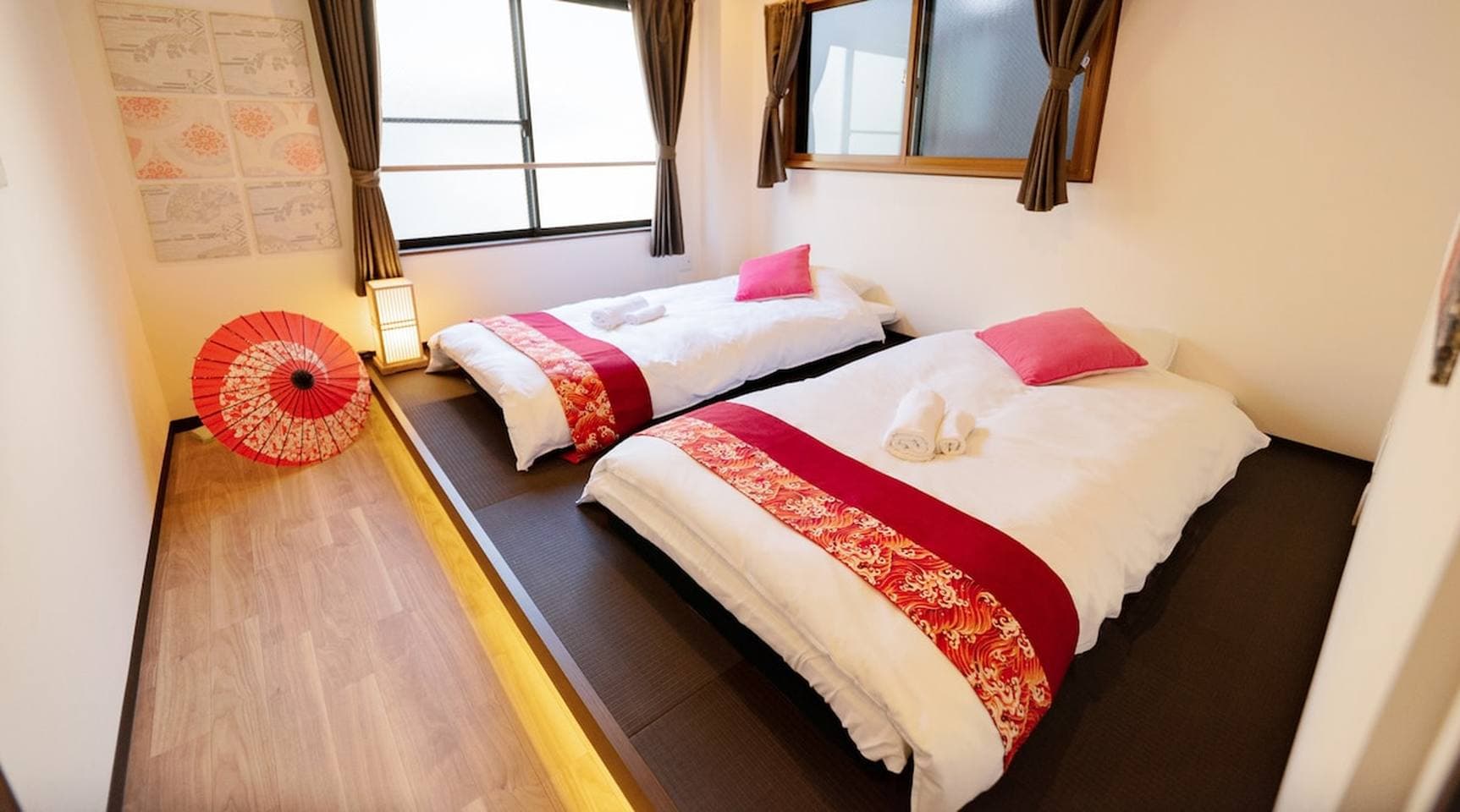 Japanese-style bedroom with two beds on a raised tatami platform and traditional decor.