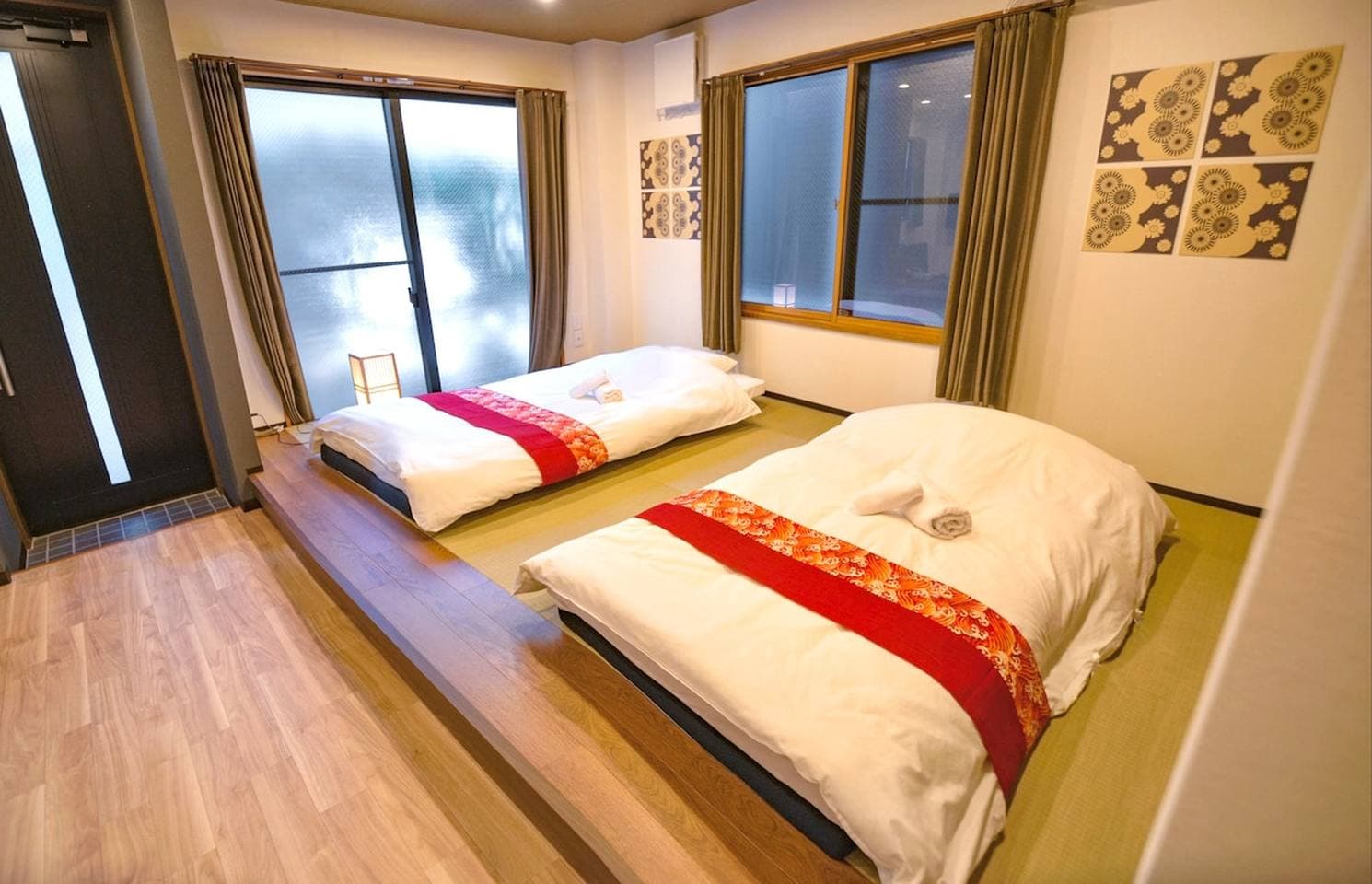 Two single beds on a raised tatami mat platform in a Japanese-style bedroom.